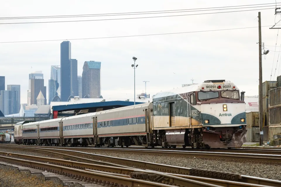 Amtrak train with downtown Seattle in background.